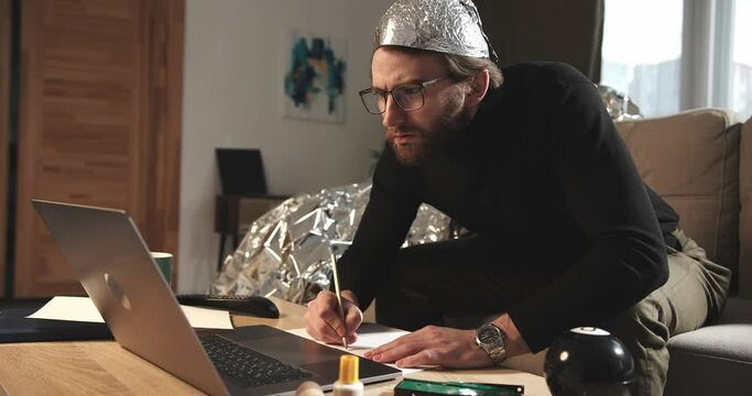 A paranoid makes notes or calculations on sheets in search of answers to pseudoscientific statements.