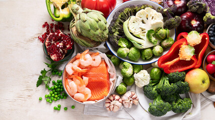 Vegetables, fish, berry on wooden background. Healthy food concept