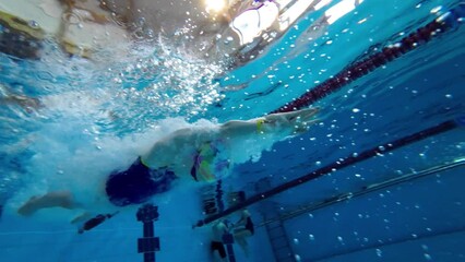 Swimmer girl dives into the water at the start in the pool. Slow motion.
