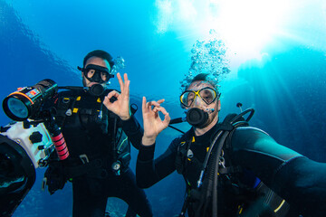 Scuba Divers Swimming in Deep Sea With Sunrays. Young Man DIver Eploring Sea Life. - 768737984
