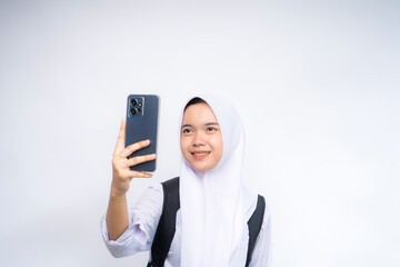 Young beautiful student woman in white and grey uniform taking selfie using mobile phone