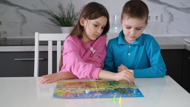 Children play board game. Portrait of two cheerful children playing with colorful cubes. Children's leisure concept. Selective focus.