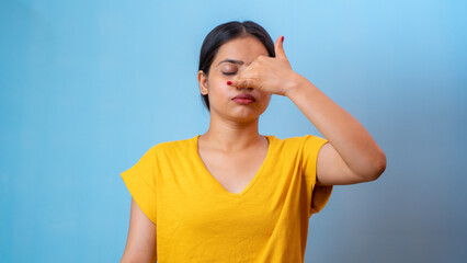 Beautiful woman practicing Anulom Vilom Pranayama, also known as Alternate nostril breathing yoga, isolated indoor home