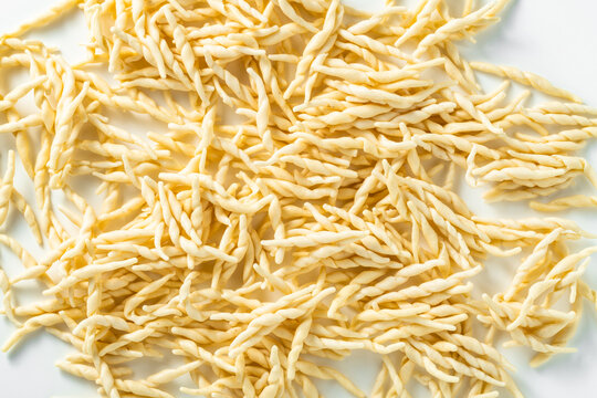 trofie . uncooked fresh Italian pasta on a white background