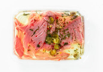 tuna carpaccio with capers in a package on white