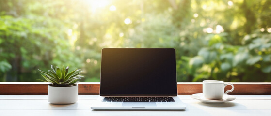 Laptop computer with blank screen on wooden table with coffee cup and green nature background .