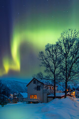 Northern lights (Aurora borealis) in the sky over Tromso with typical Norwegian houses - Tromso, Norway