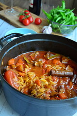 Rice with lamb meat and vegetables on a plate on a wooden table