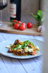 Rice with lamb meat and vegetables on a plate on a wooden table