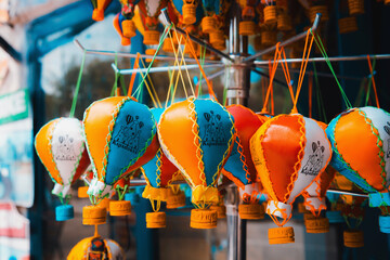 Cappadocia-themed vibrant balloon ornaments, a trendy mix of bright oranges and blues, dangling in...