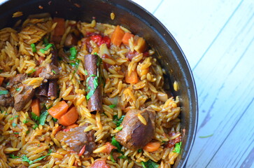lamb stewed with tomatoes and orzo, background of greek traditional food youvetsi
