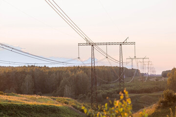 Fototapeta premium Power transmission lines (power lines) on steel supports against the background of the evening sunset sky.