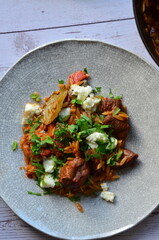 lamb stewed with tomatoes and orzo, background of greek traditional food youvetsi