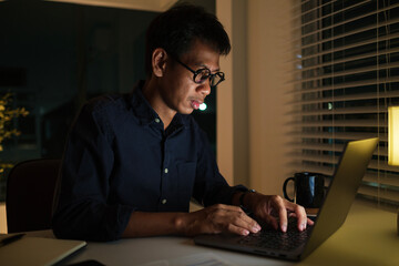 Focused businessman working overtime in an office at night.