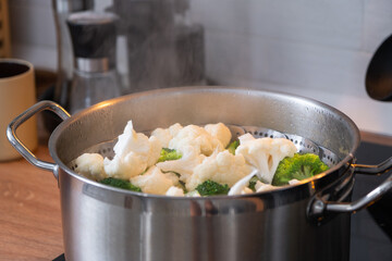 Broccoli and cauliflower are steamed in a saucepan - healthy diet, baby food, cooking in a steamer	
