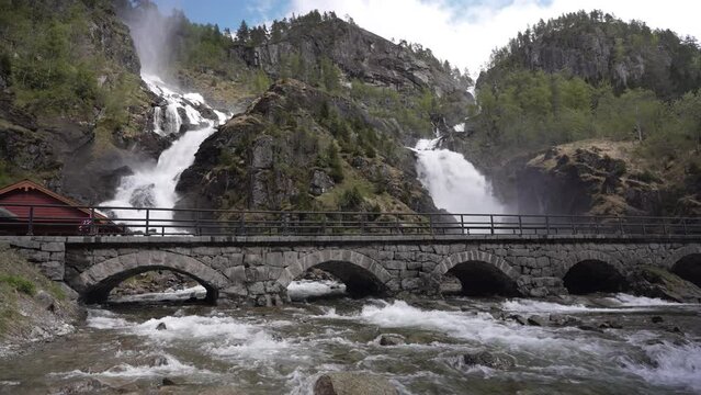 old stone bridge of the road passing by the spectacular waterfalls of Latefossen in Norway near Odda.