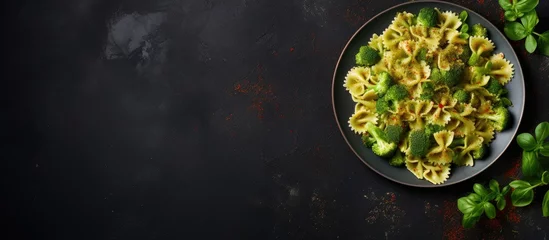 Foto op Plexiglas Freshly cooked Vegan Farfalle pasta covered in a creamy spinach sauce, served with nutritious broccoli, brussels sprouts, and green beans on a stylish dark stone plate © vxnaghiyev