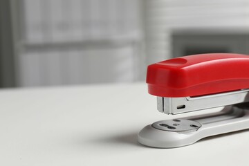 One stapler on white table, closeup. Space for text