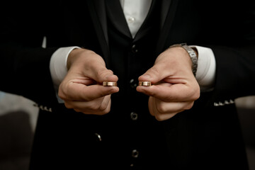 The groom holding the wedding rings in his hand	 - obrazy, fototapety, plakaty