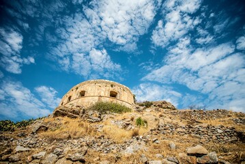 Low-angle shot of the fortress against the background of a blue cloudy sky. Lindos, Greece.