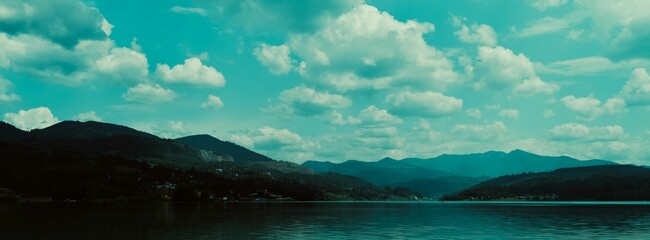 Picturesque landscape of a tranquil lake nestled in the majestic mountain range © Wirestock