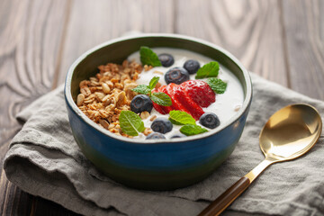 Homemade crispy granola, yogurt and berries in bowl on white background. Healthy breakfast.