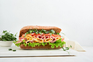 Sandwich. One fresh big submarine sandwich with ham, cheese, lettuce, tomatoes and microgreens on...