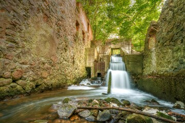 Outdoor scene featuring a lush waterfall cascading down a rocky wall