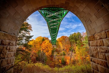 Close-up of the Cut River Bridge in Michigan, surrounded by vibrant fall colors of the forests © Wirestock