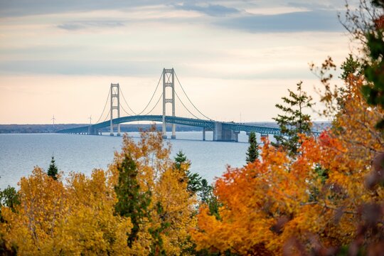Aerial view of the Mackinac Bridge in Michigan, surrounded by vibrant fall colors of the forests