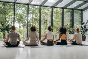 Foto op Canvas People meditating near panoramic windows with forest view  © sashafolly