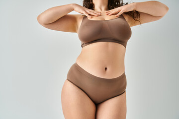cropped shot of body attractive curvy woman in underwear touching to neckline with hands