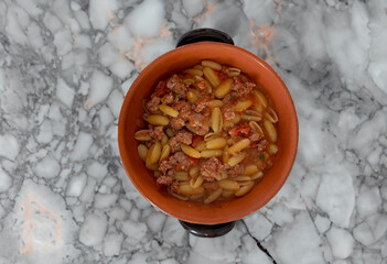 malloreddus or Sardinian gnocchetti, typical Sardinian pasta, with wild boar sauce, basil and pecorino cheese.