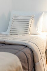Cozy bed with brown and light beige duvets and white pillows