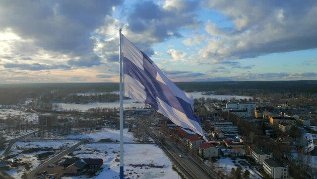 Slow motion of the flag of Finland fluttering in the wind on a pole with the sky in the background