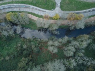 a long walkway through a lush green park area next to water