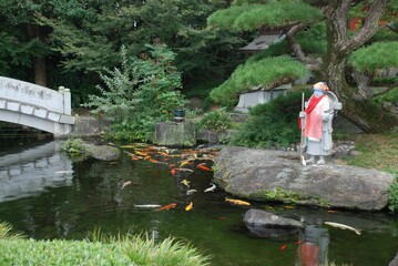 Scenic view of a sculpture and a tranquil pond at a Japanese Temple