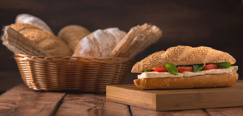 cesto de pães com um sanduiche de queijo fresco