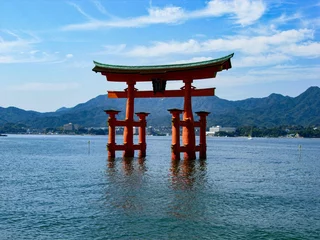 Gardinen Traditional Japanese torii gate floating in a tranquil body of water in Itsukushima. © Wirestock
