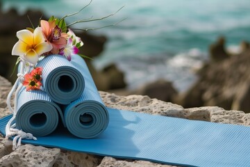 yoga mat and a bag of exotic blooms on serene coastline - obrazy, fototapety, plakaty