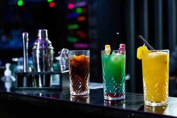 three different cocktails. coke cocktail, blue cocktail and yellow cocktail