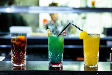 three different cocktails. coke cocktail, blue cocktail and yellow cocktail