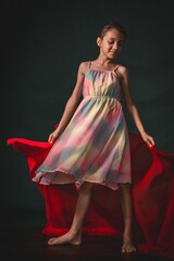 Girl wearing a colorful dress holding a red cloth