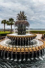 Fototapeta premium Serene fountain rests in the center of a verdant park, with towering palms encircling the area