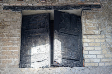 burnt wood from original doors and windows. Ancient city in Herculaneum archaeological park, Naples, Italy