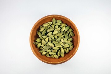 a wooden bowl with some cardamoa seeds in it