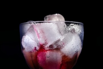 Close-up of ice cubes sticking out of a glass on a black background