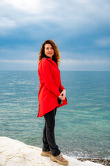 girl in a red jacket on the seashore - 768827737