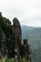 Steep cliff of the Pinnacles, Coromandel, New Zealand with lush hills in the background