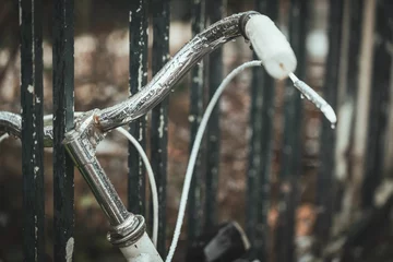 Foto auf Acrylglas Vintage-style bicycle propped up against a metal railing, with a backdrop of rusted iron bars © Wirestock